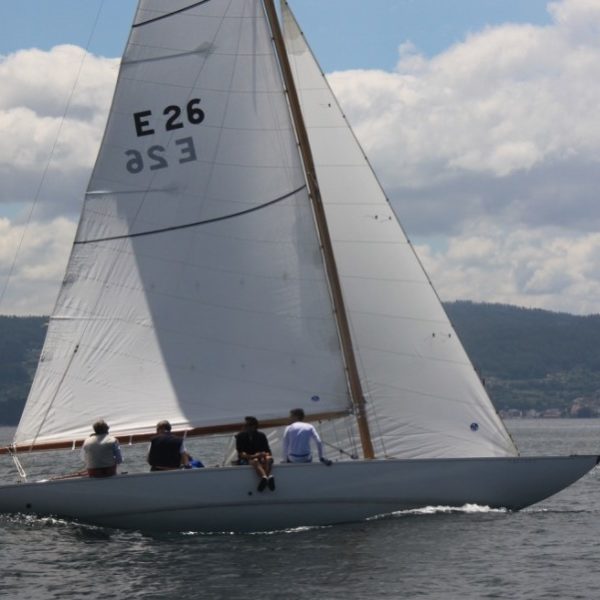 Six Metre sailing boat with white hull and white sails.