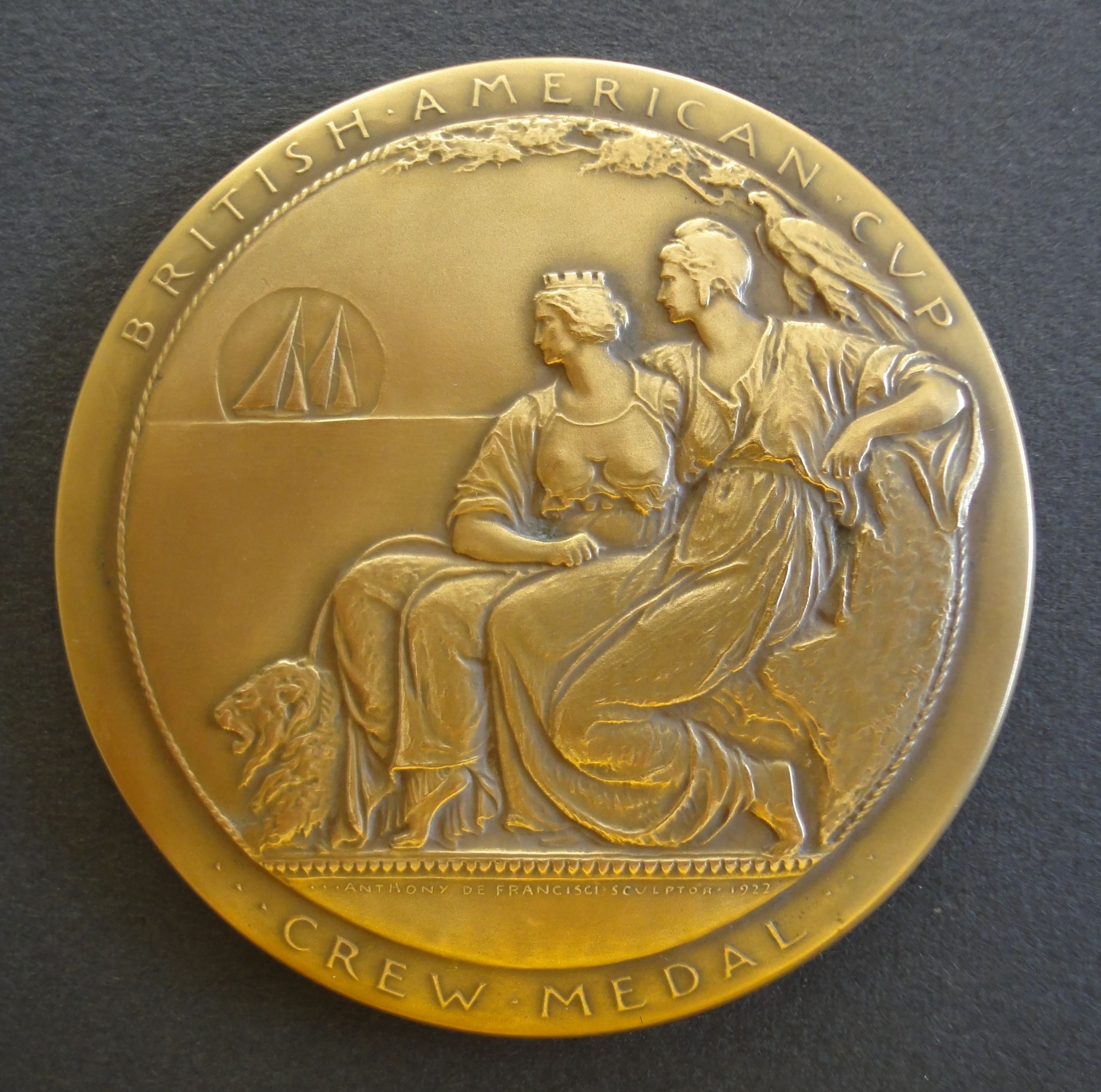 Obverse of medal with two seated female figures watching sailing boats.