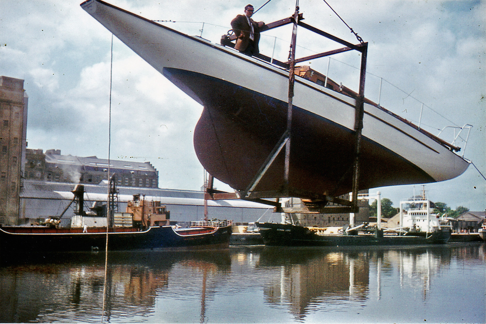 White boat hoisted above a dock in a cradle.