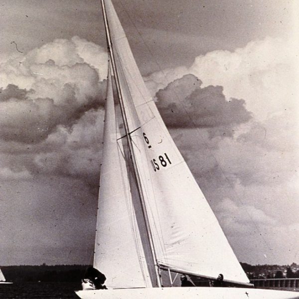 black and white photograph of a six metre boat sailing on water