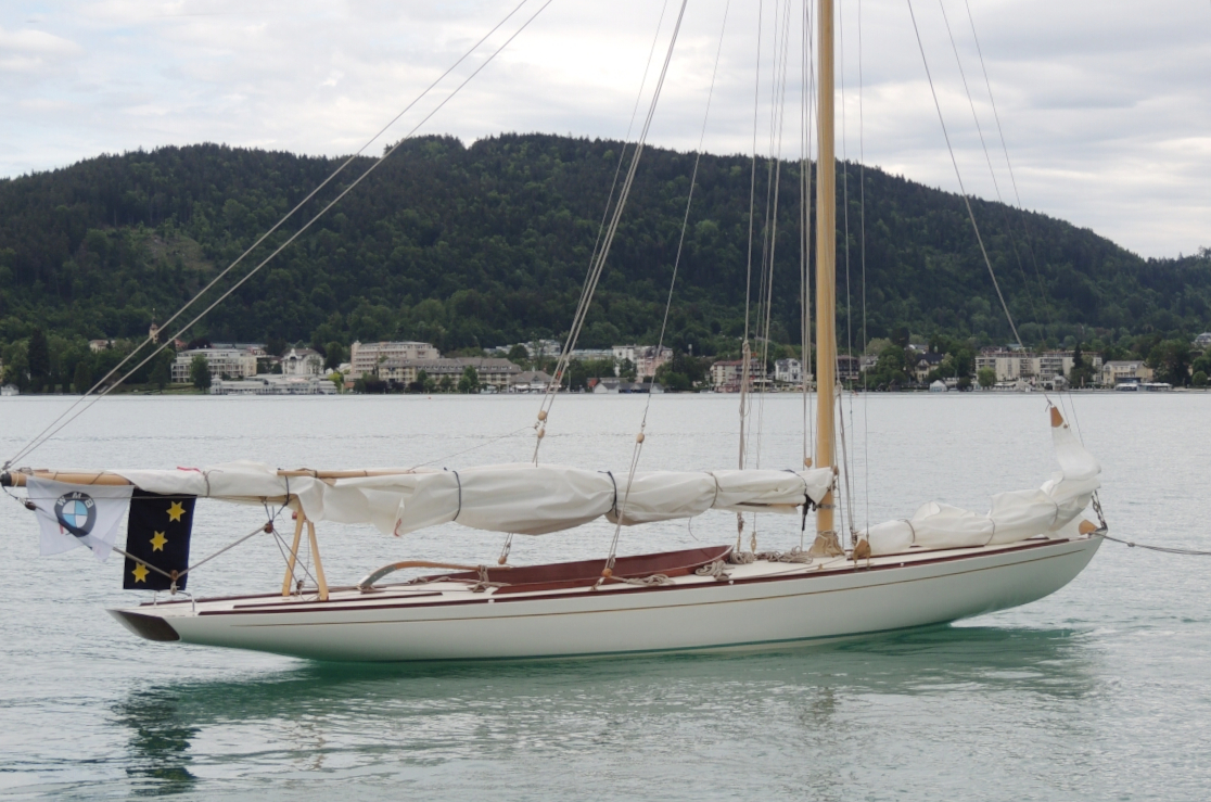 Boored anchored in a lake with sails down
