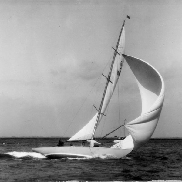 Black and white photograph of a Six Metre sailing boat with spinnaker hoisted.