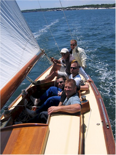 five crew smiling for the camera in a yacht
