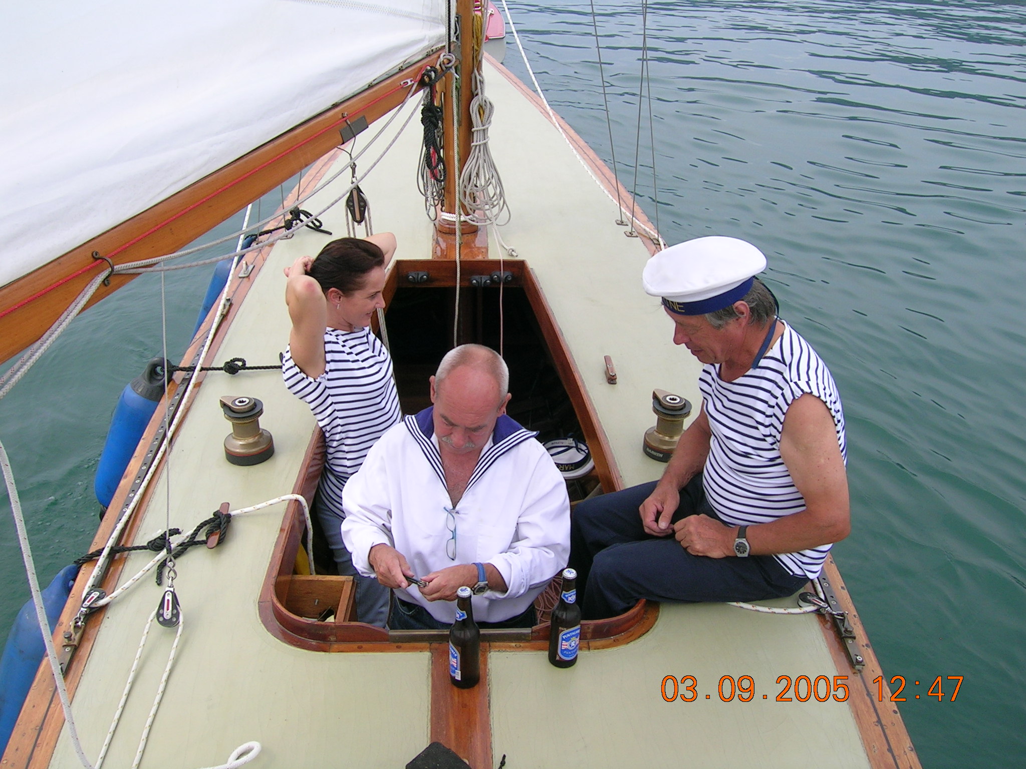 three crew in the cockpit of a yacht, seen from above