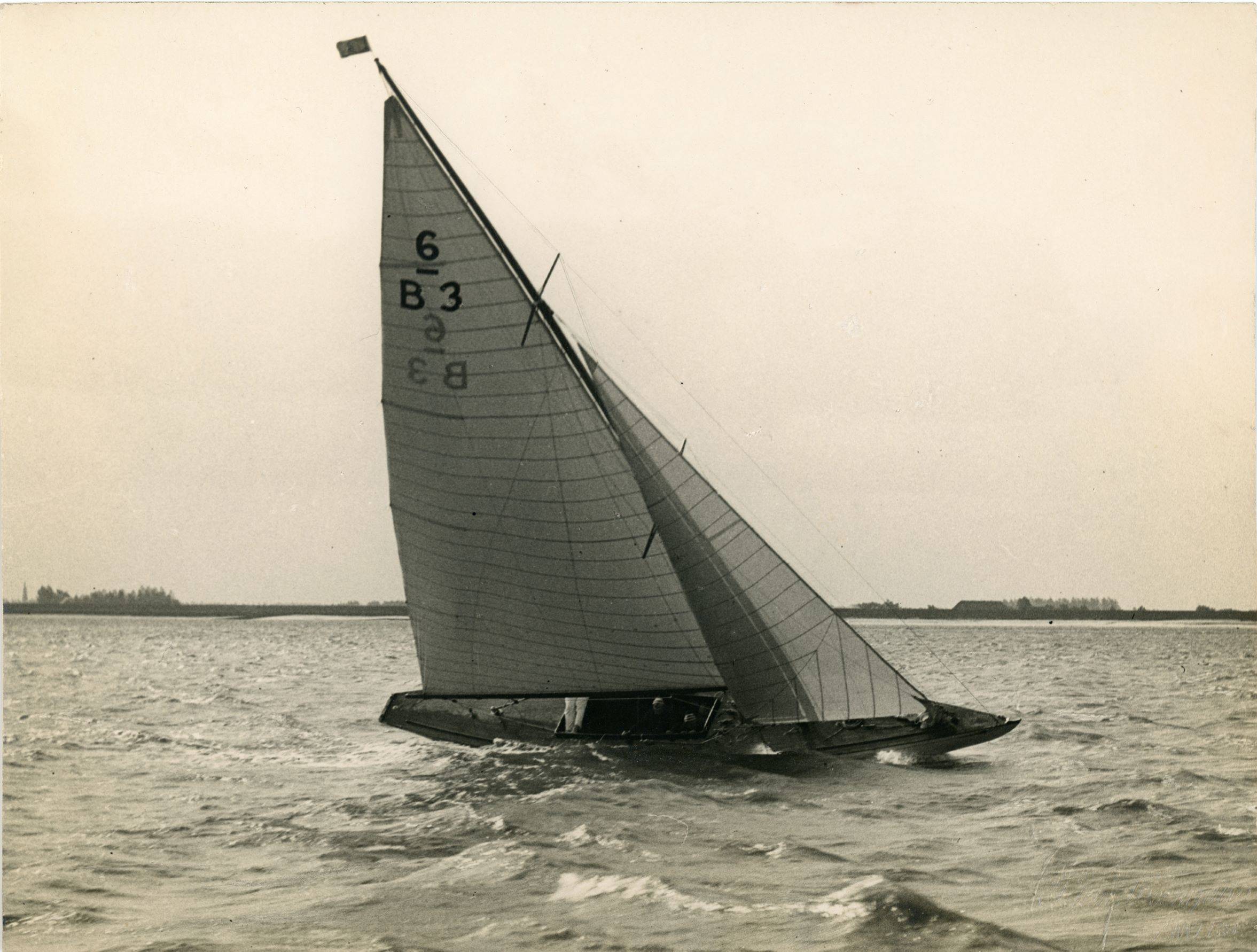 Black and white photograph of Six Metre sailing boat close hauled.