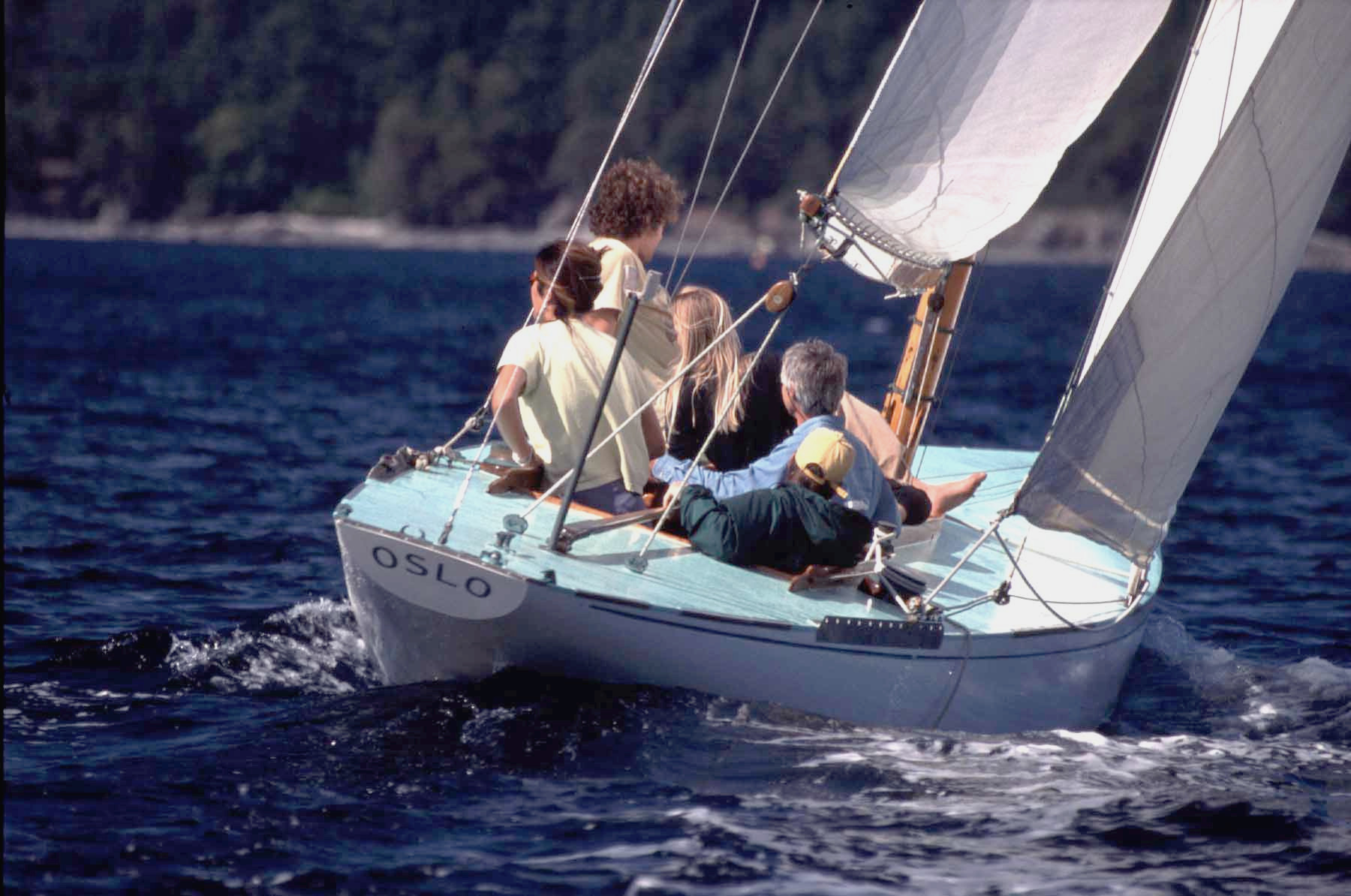 A blue decked yacht sailing with 5 crew.