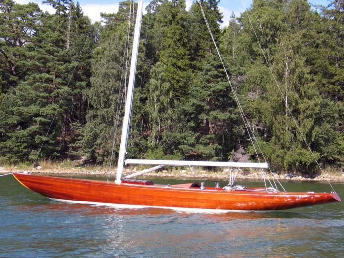 A red wooden yacht hull, moored.