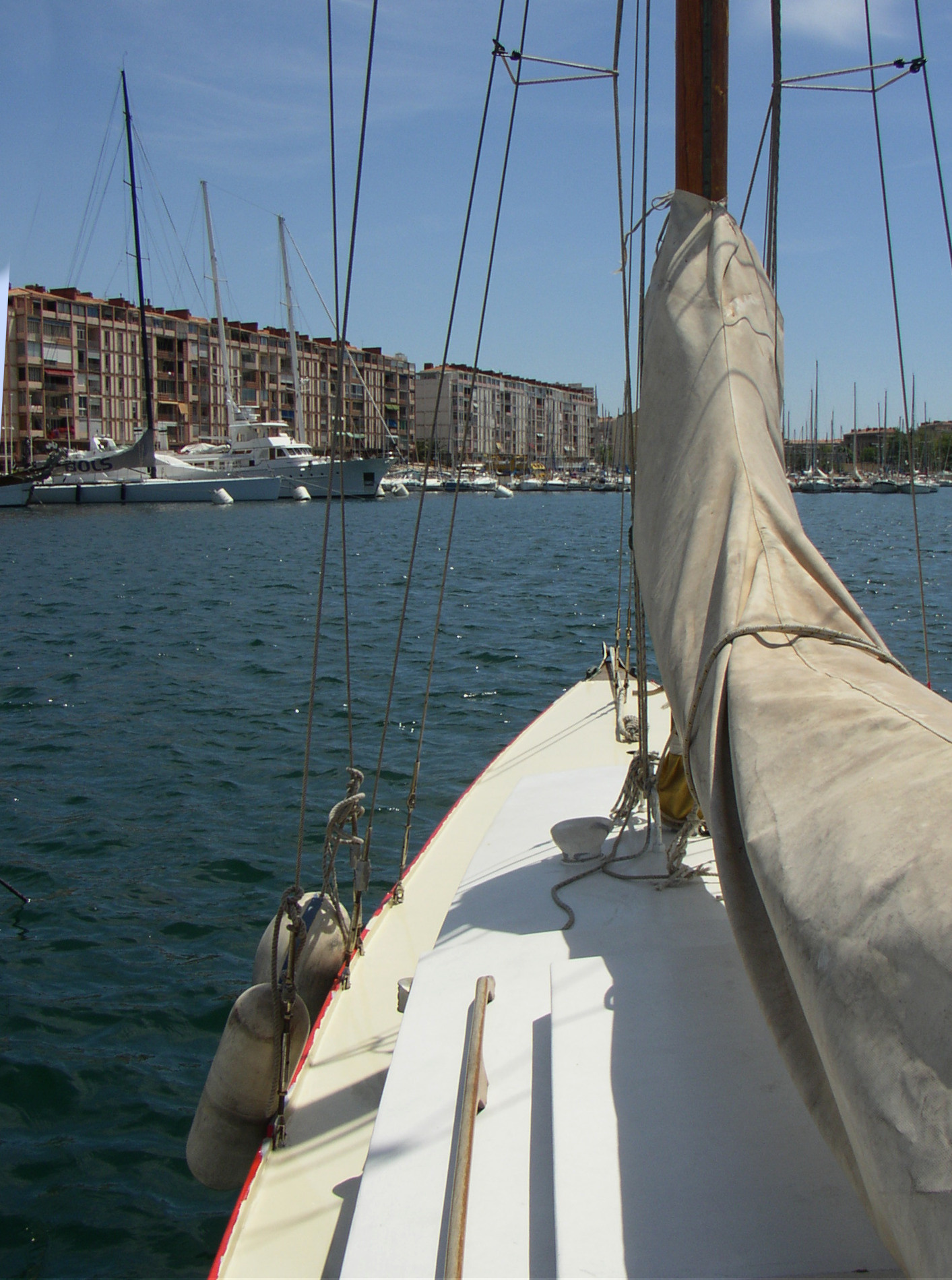Detail photo of the bow of a white deck of a moored yacht.
