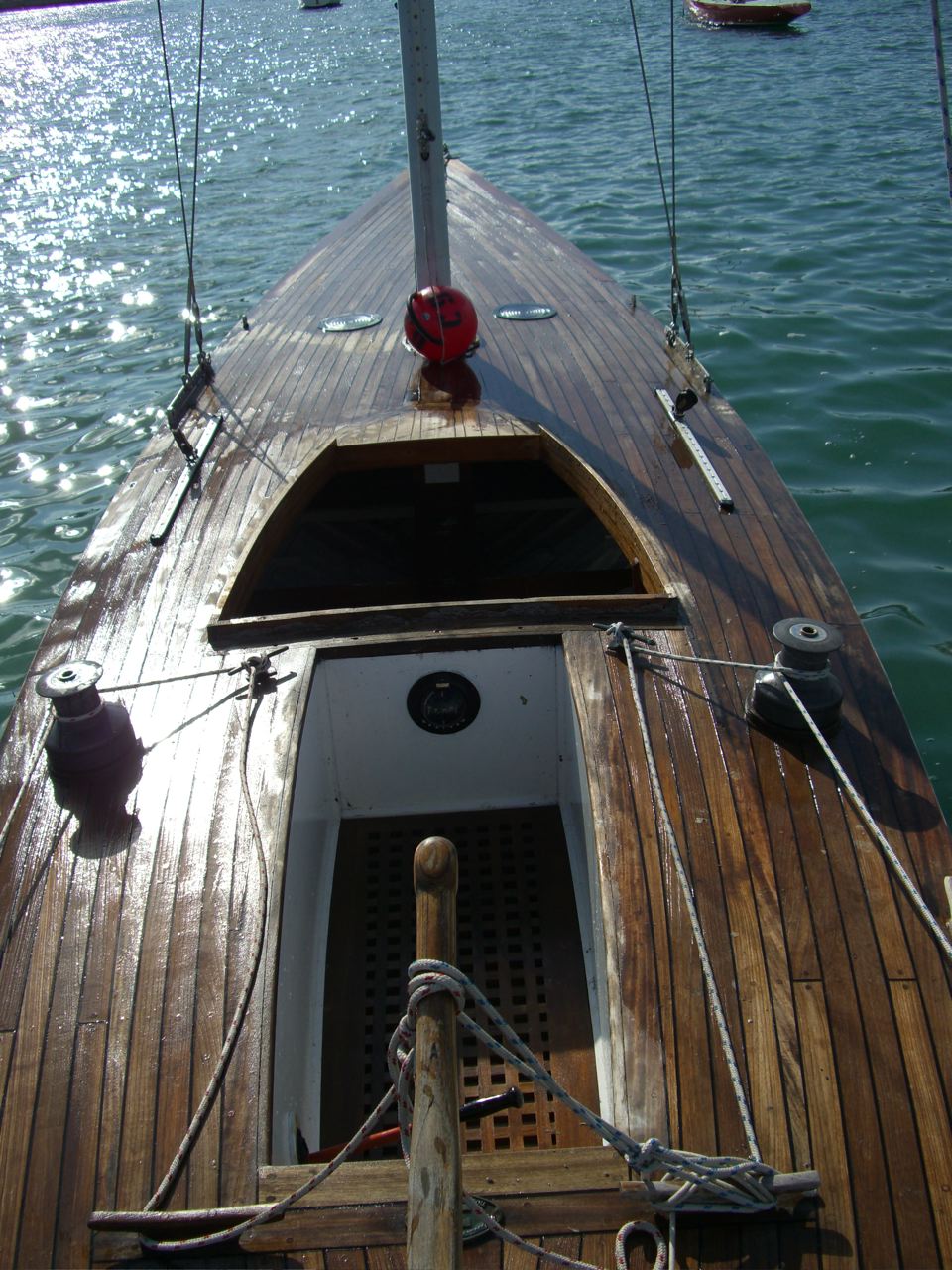 Bow section and cockpit of a yacht deck, moored in blue water