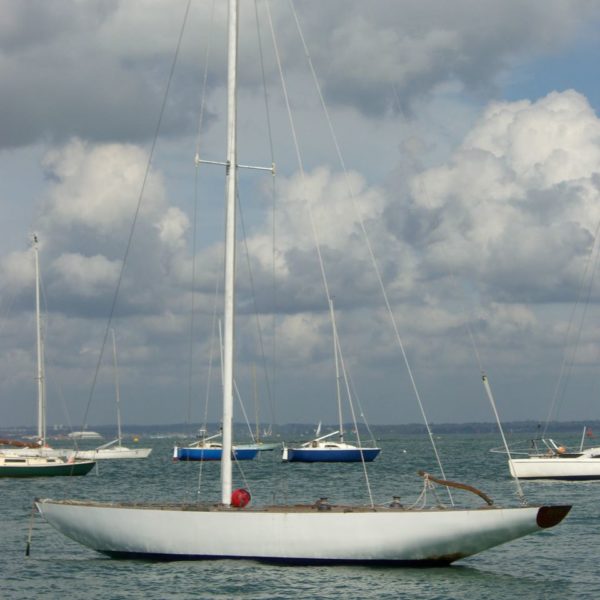 A white yacht moored under a cloudy sky