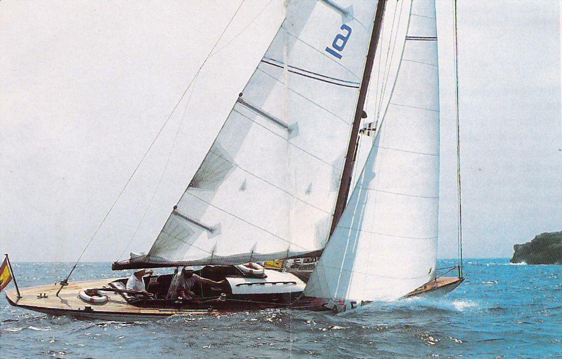 A colour photo of yacht with a white sail sailing in blue waters