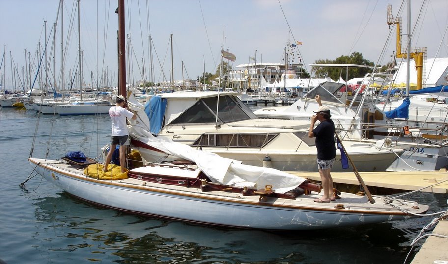 A colour photo of a wooden yacht moored