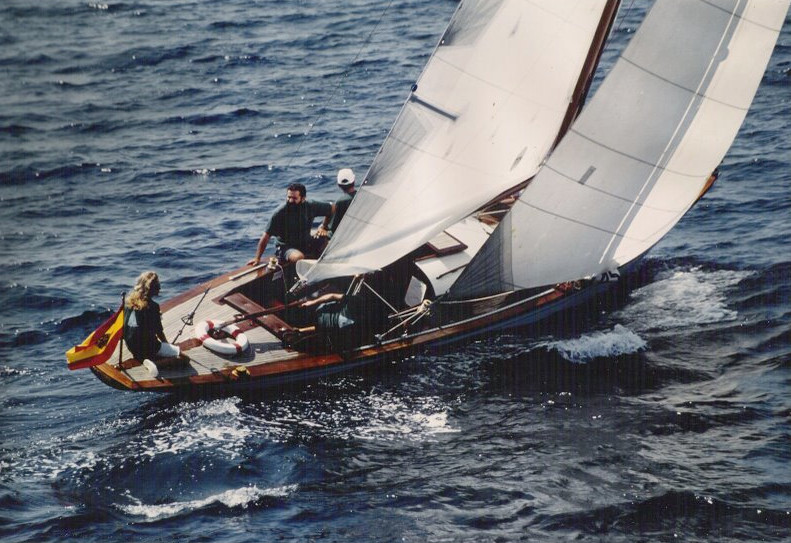 A colour photo of a wooden yacht sailing