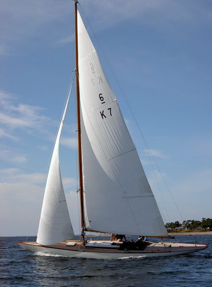 A white yacht with a white sail on blue water