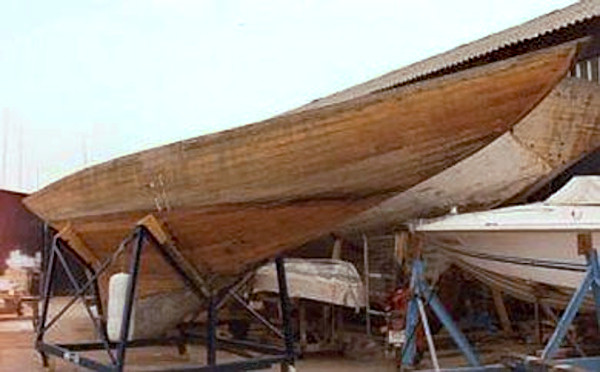 Bare wooden hull on the hard.