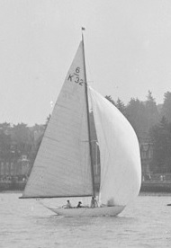 B&W photograph of a Six Metre boat sailing on water, with crew visible on deck